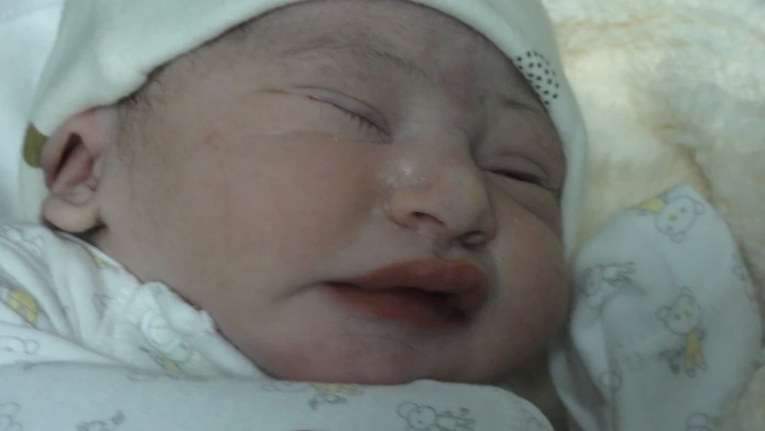 a close up of a baby laying on top of a bed