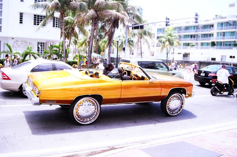 a car in the middle of traffic, with a motorcycle parked nearby