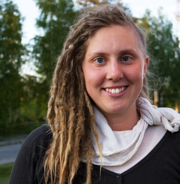 a girl is smiling with a white scarf around her neck