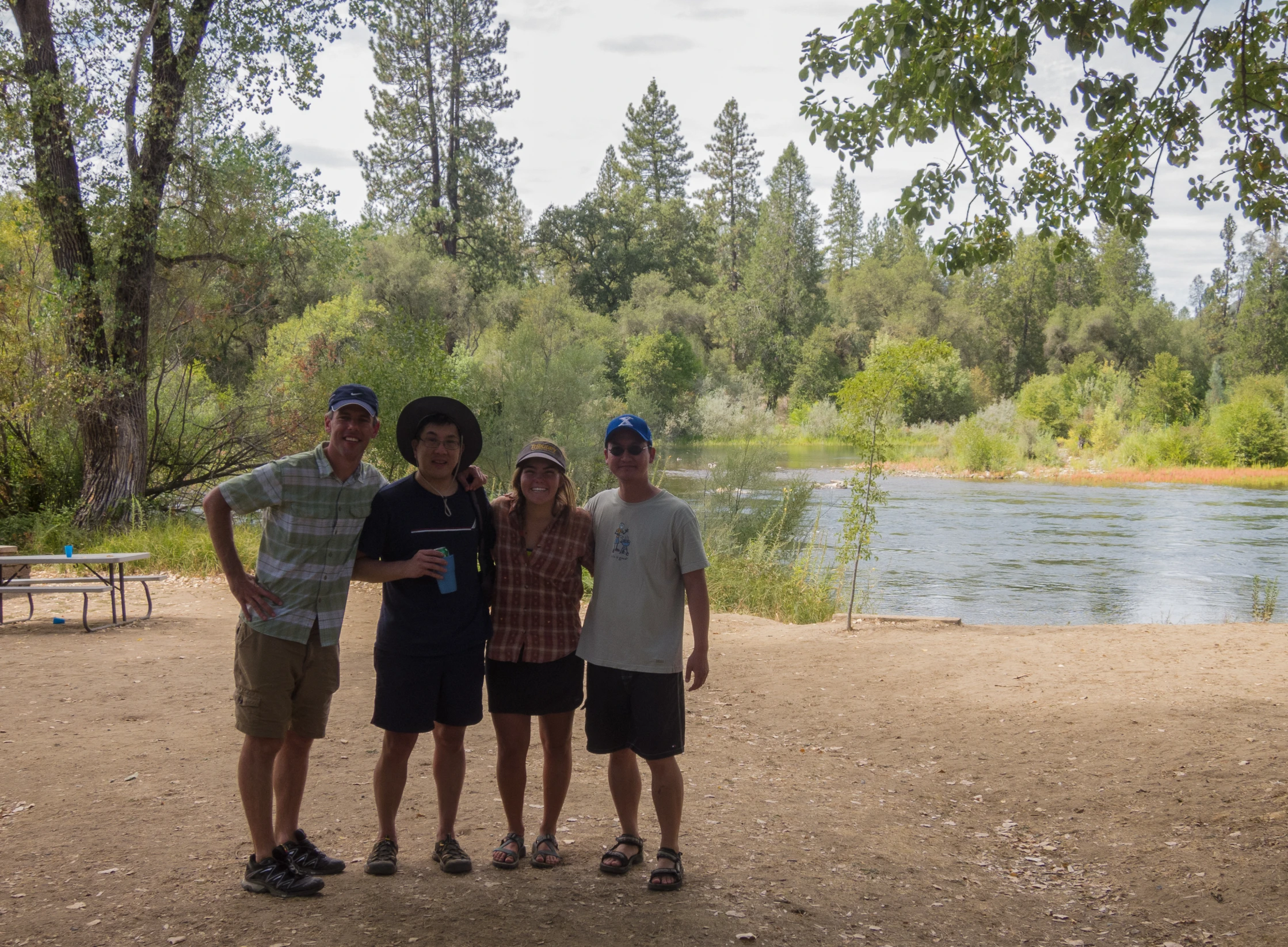 the three people are standing near the water