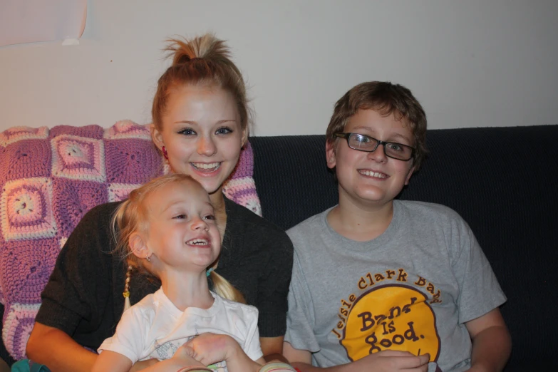 a family sits together on a couch and smiles