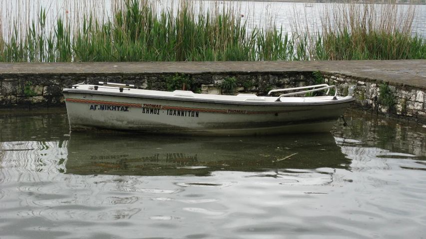 the small white boat sits in the water