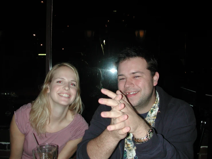 two people sitting at a table with glasses