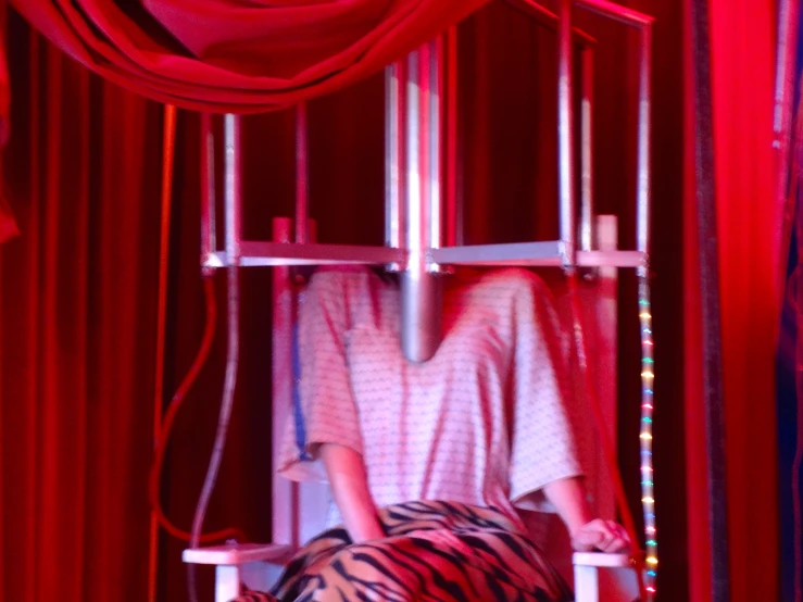 a person is taking a picture in a cage with red curtains