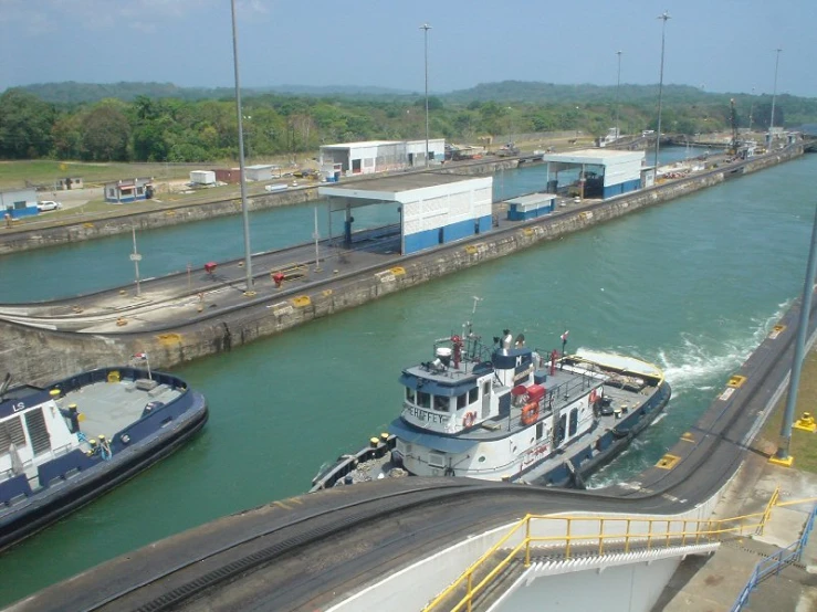 large white boat in waterway with smaller ones nearby