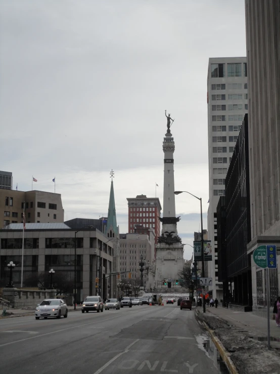 city skyline with tall buildings, vehicles and a statue