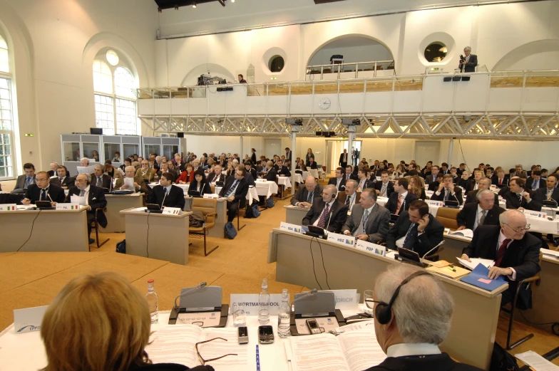 large group of people sitting in a hall at a meeting