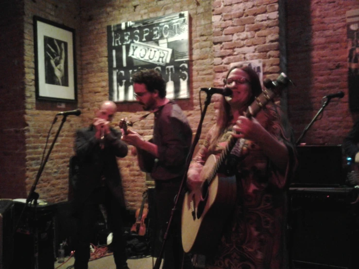 the three men are singing and playing instruments