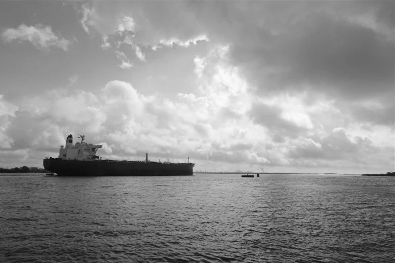 an ocean view with a ship and boats in the background