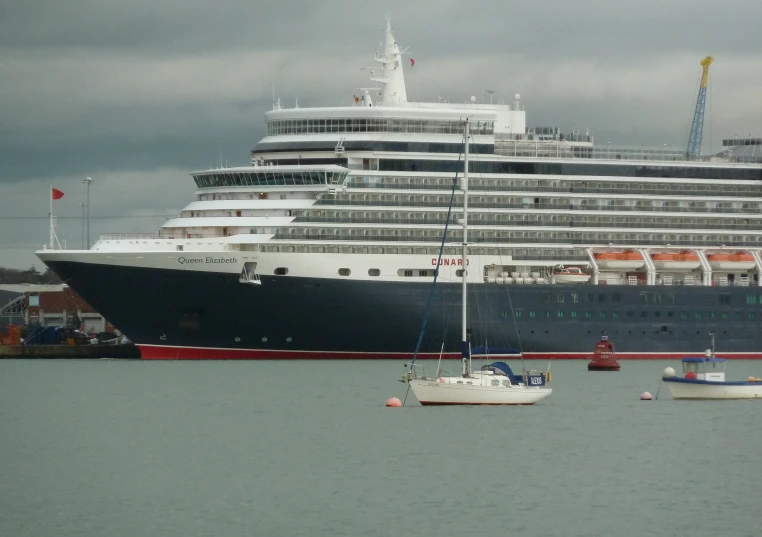 a large cruise ship docked with some small boats in the water