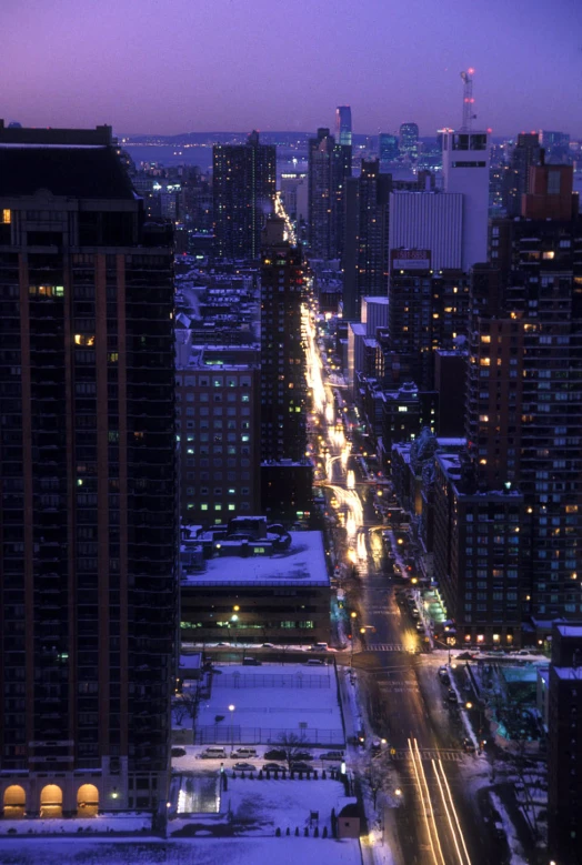 an image of street lights and city skyline at dusk