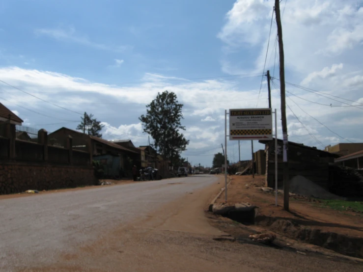 an empty street has a sign posted for sale