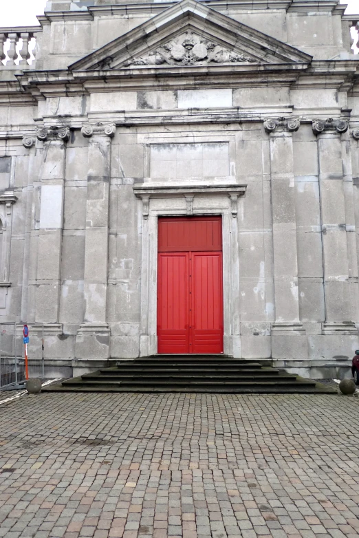 an old, stone church with a bright red door