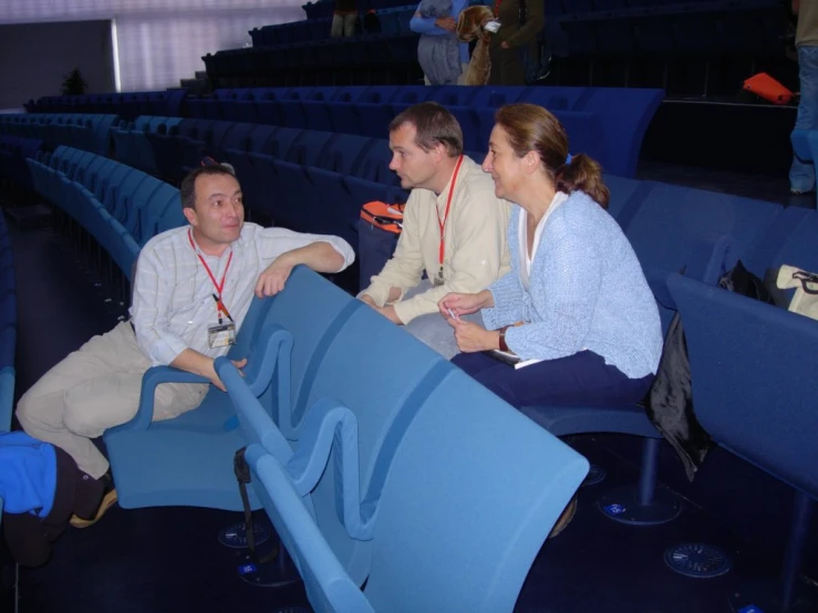 two people talking to each other while sitting in seats