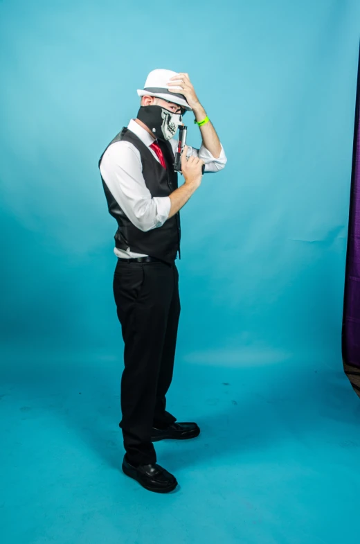 a man with a weird looking head dress holds a pipe up to his mouth