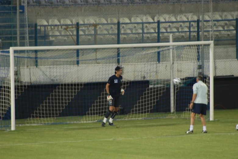 two soccer players playing in the field of an arena