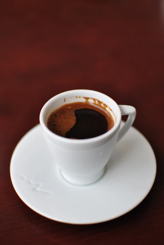 a cup of coffee is sitting on a white saucer