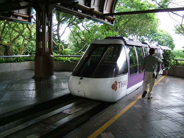 two people on a walkway next to a passenger train