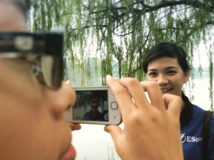 woman taking po of man with cellphone with reflection