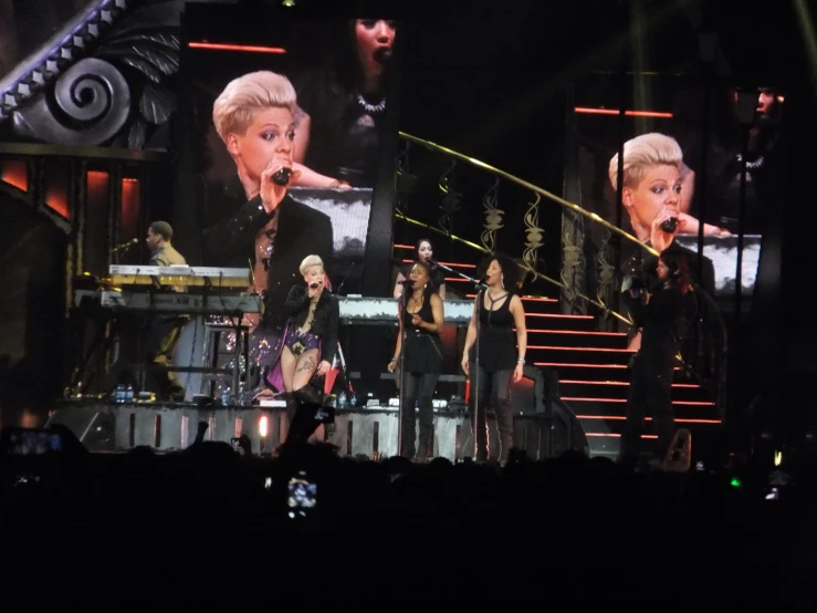 a group of women in black outfits performing on stage