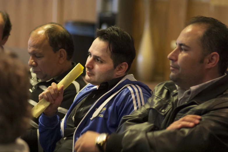 group of men sitting and looking to the right