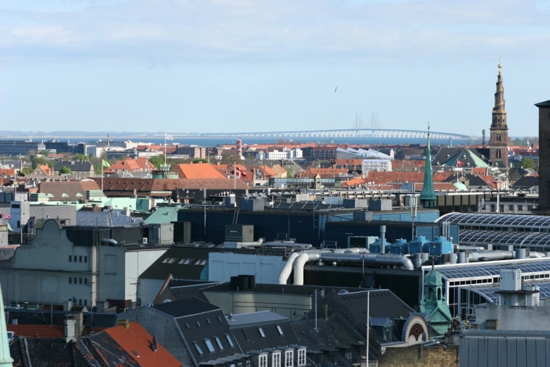 a city has rooftops with a bridge in the distance