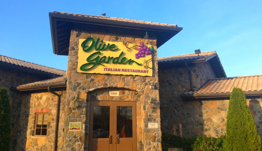 a restaurant with stone front entrance with an interesting sign