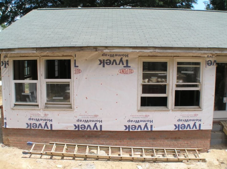 a house under construction has windows and siding on the wall