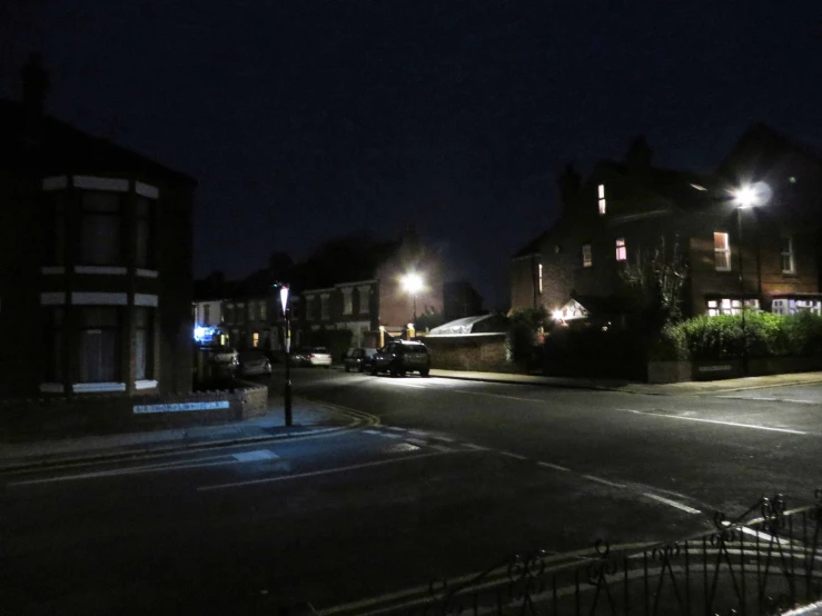 a dark city street at night with street lights lit up