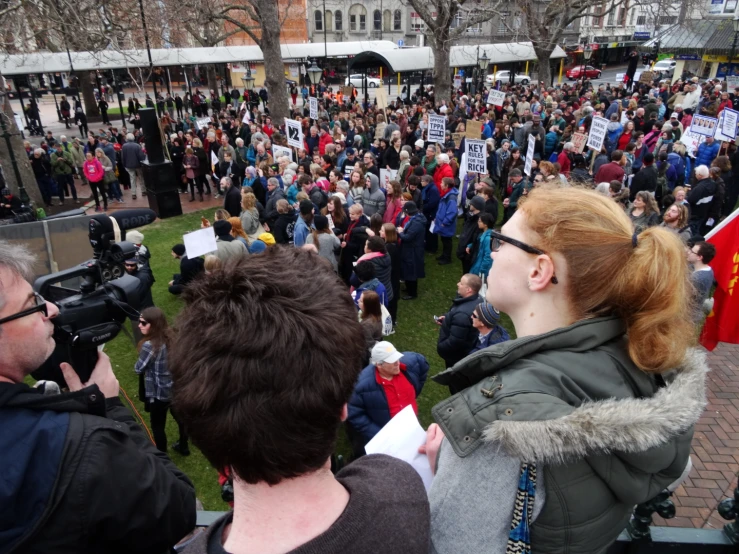 a woman standing in front of a crowd with a camera