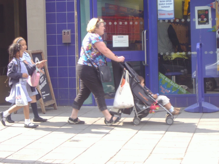 a person hing a stroller with some small children