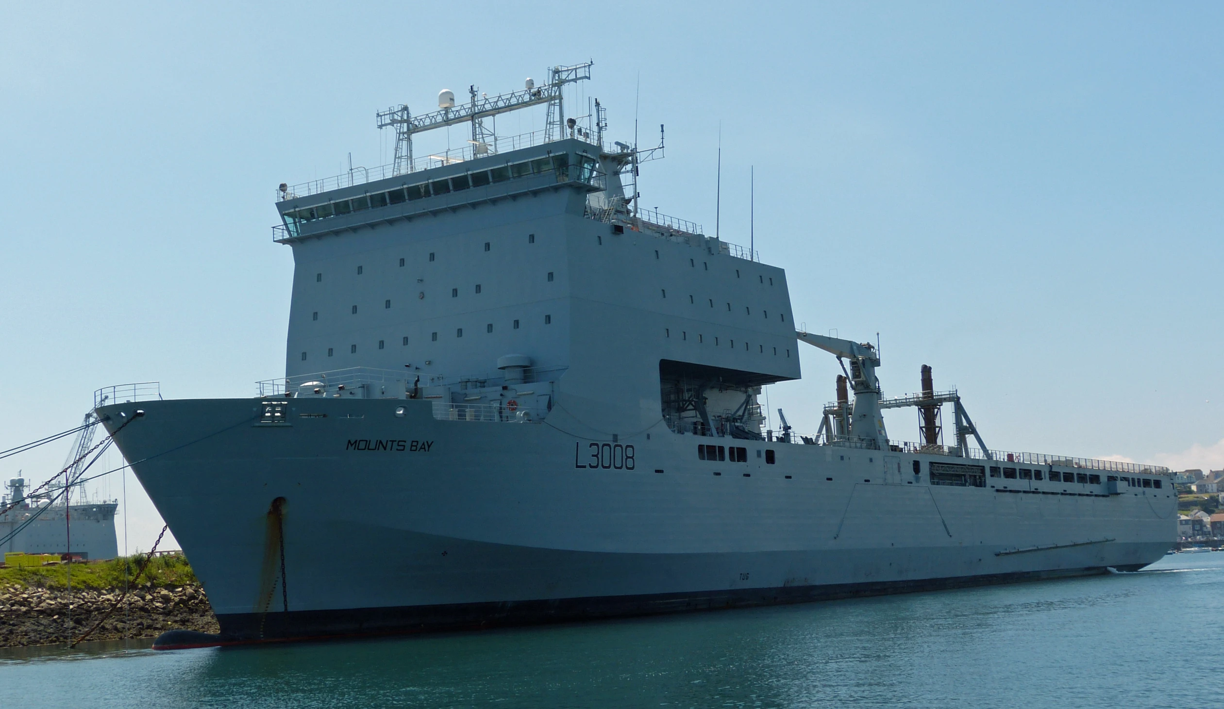 the large ship is in the water and the masts are visible