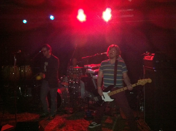 a group of people playing instruments on stage at night