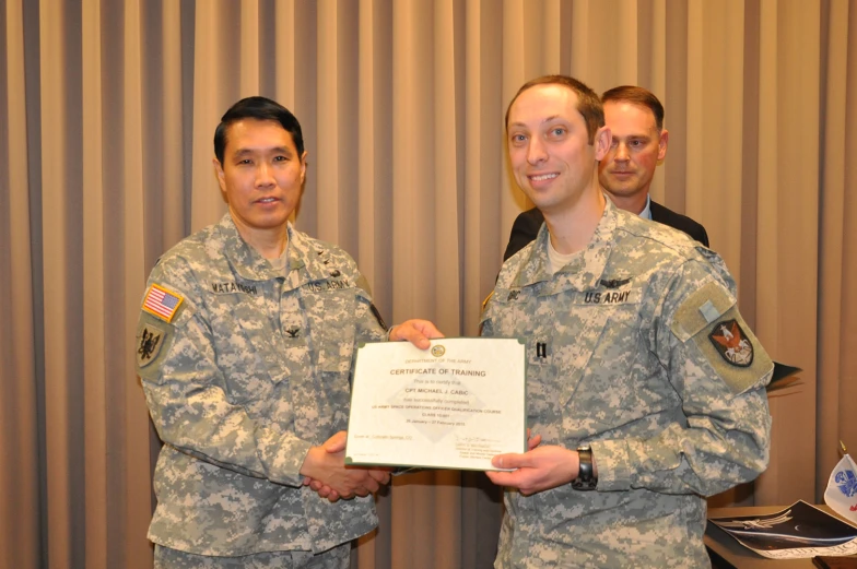 two men in military uniforms holding an award plaque