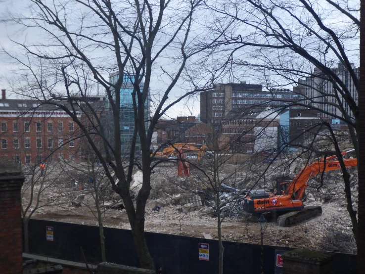 city construction site with large dump trucks and trees