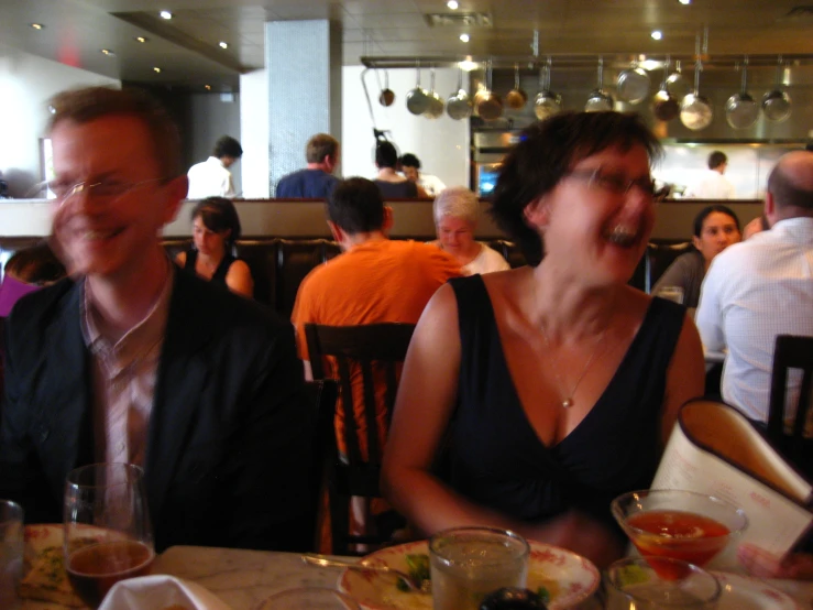 two people eating at a table next to each other