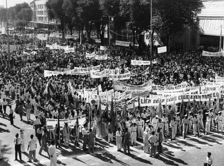 many people in black and white are standing with banners