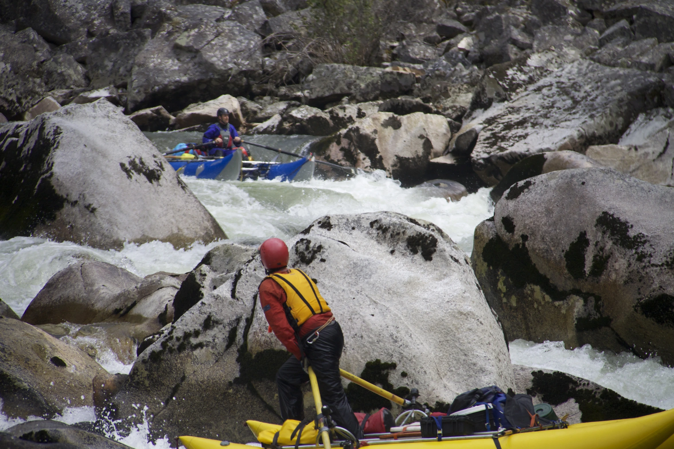 people are floating down a rocky river in rafts