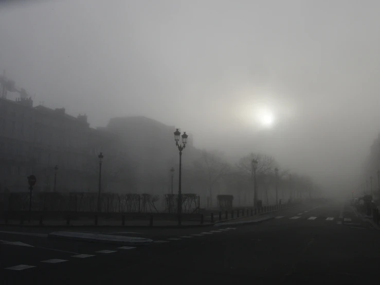 a foggy street with a light in the distance