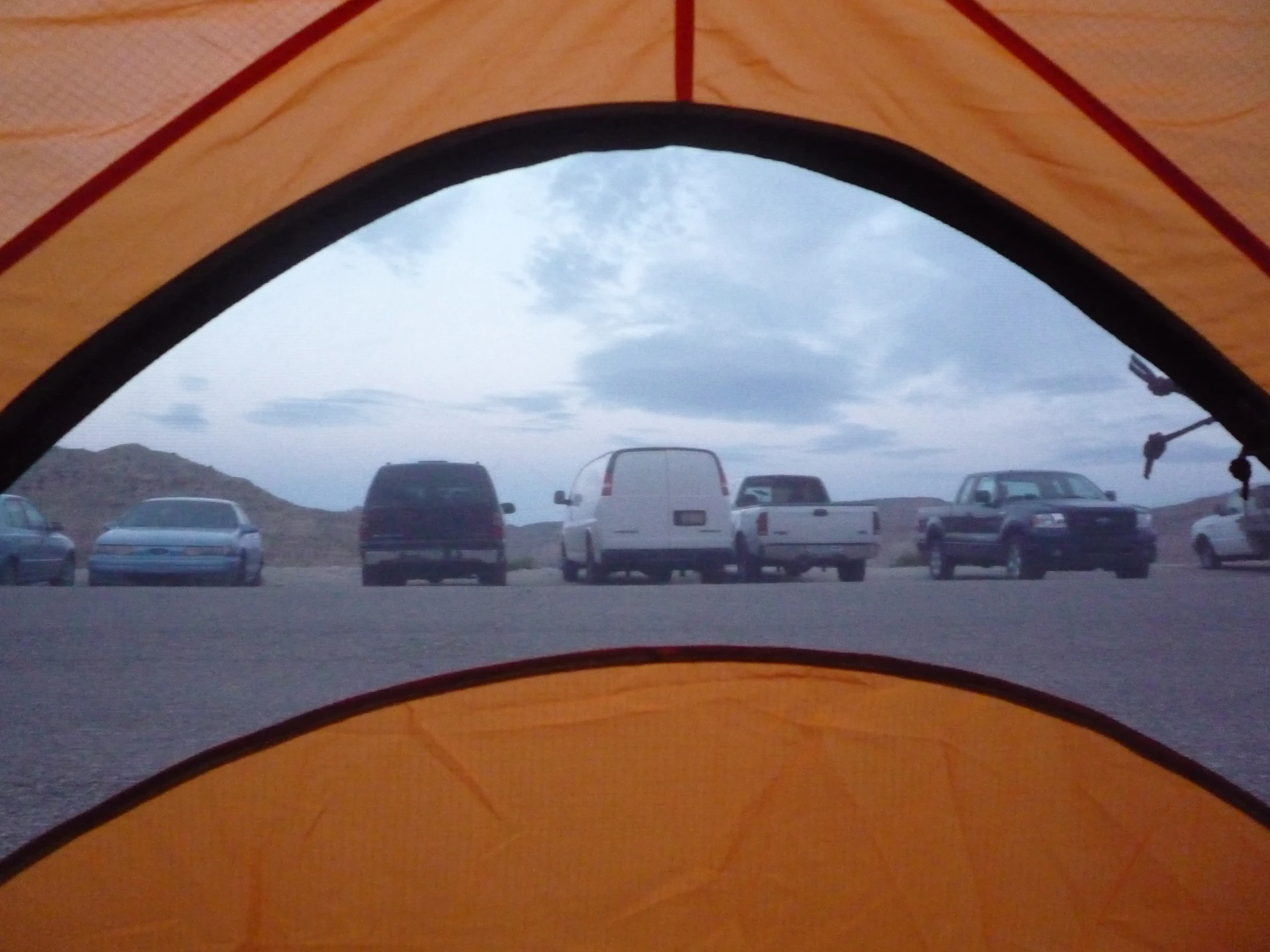 a tent in the middle of parking lot full of cars