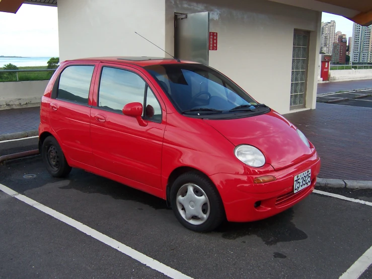 a small red car parked in a parking space