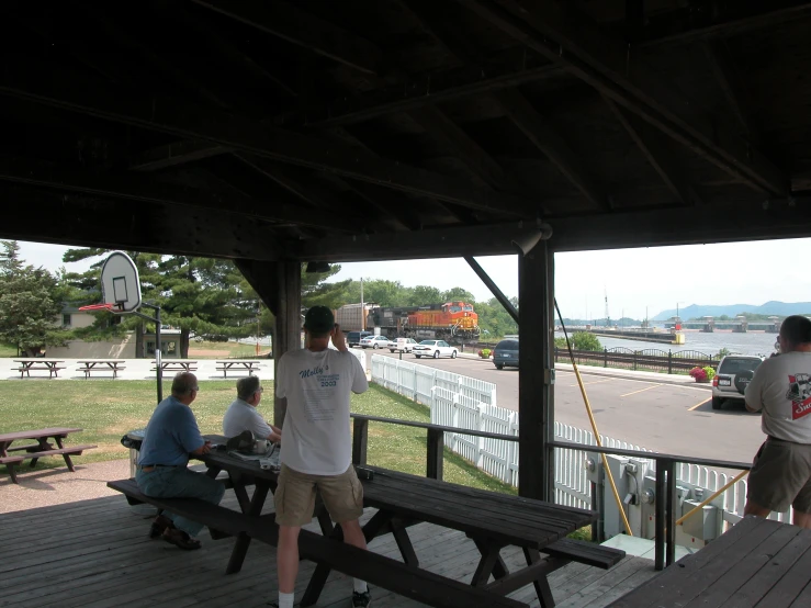 the people are sitting on benches under the boardwalk