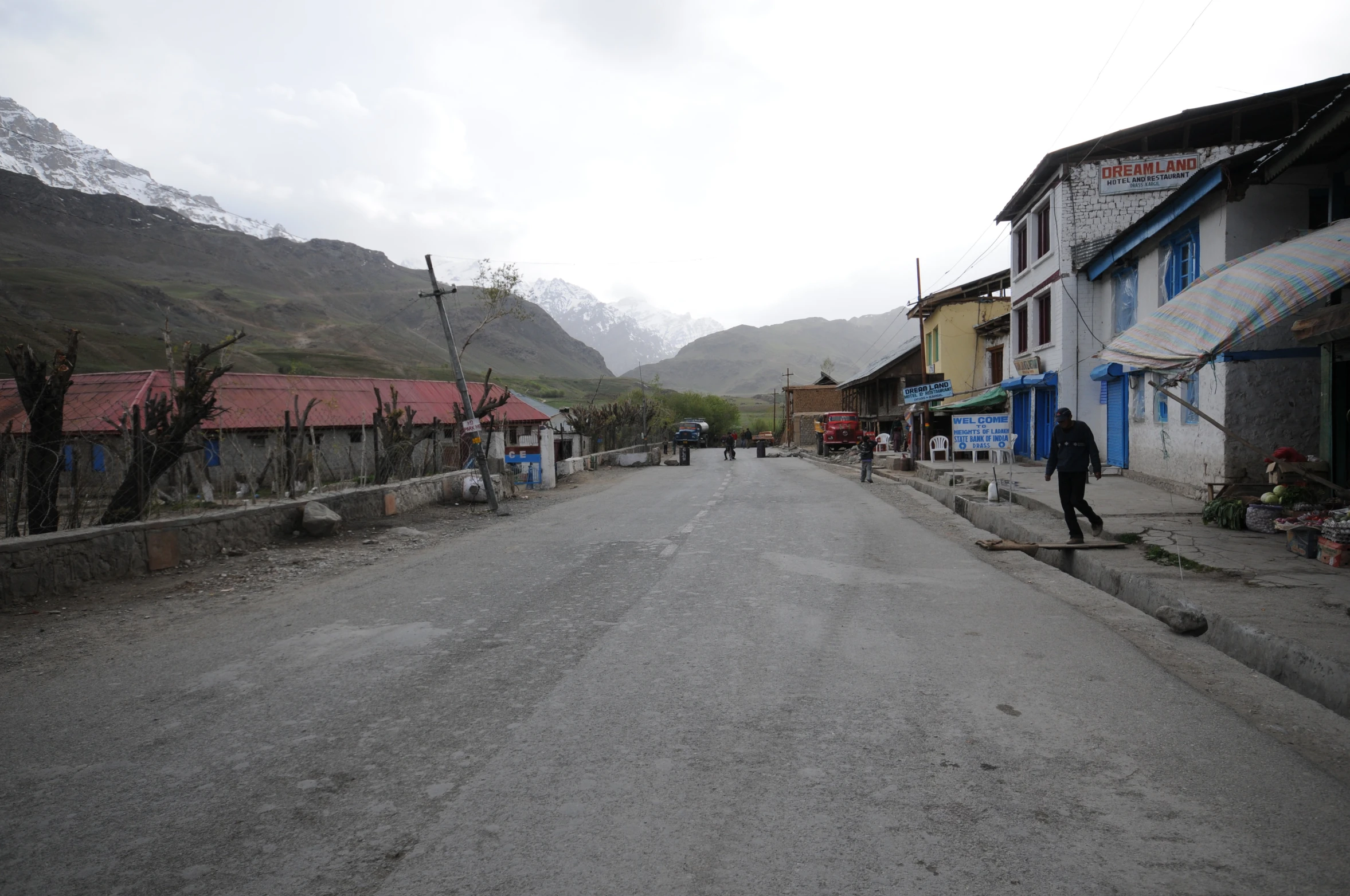 people in the street next to some small houses