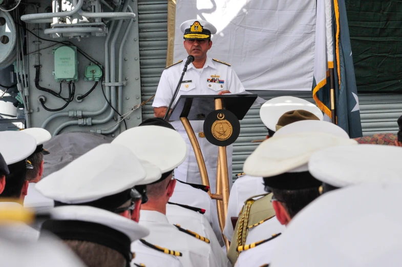 a navy officer speaking to some military officials