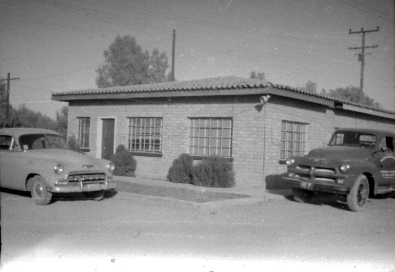 two old fashion cars parked in front of a house