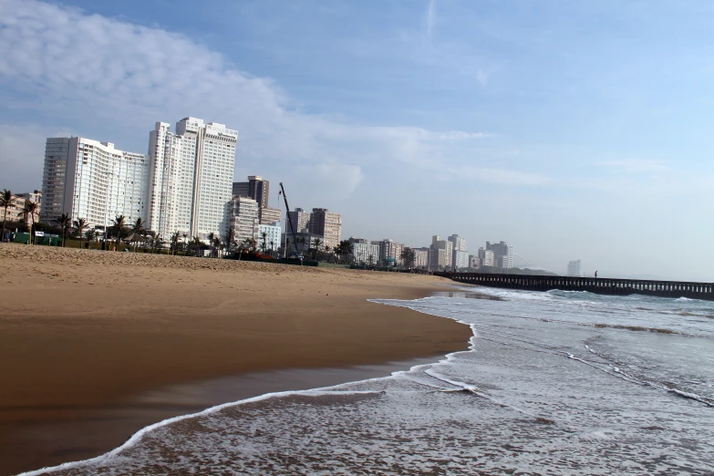 a sandy beach with waves crashing on the beach