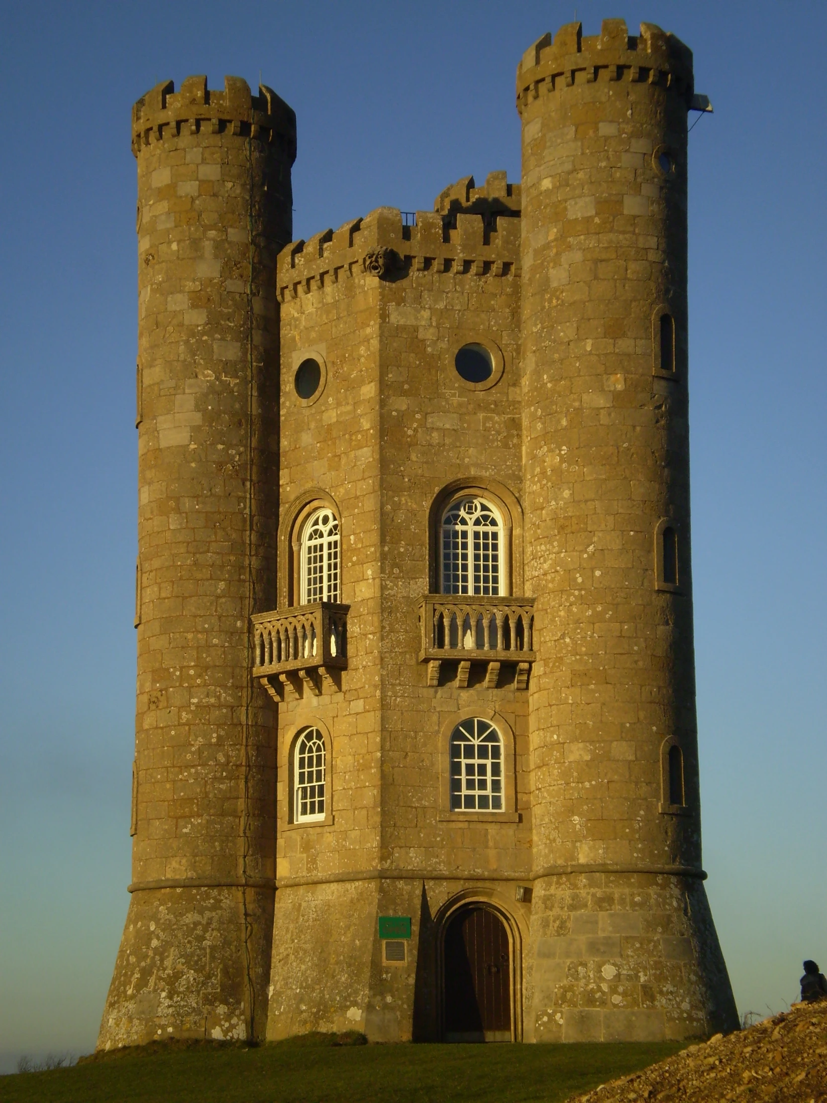 a tall castle sitting on top of a green field