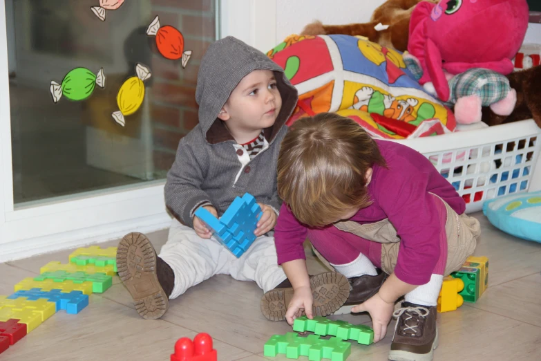 two children playing with toys on the floor