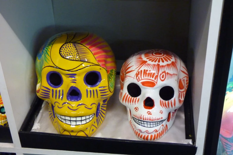 there are two colorful skulls in the display case