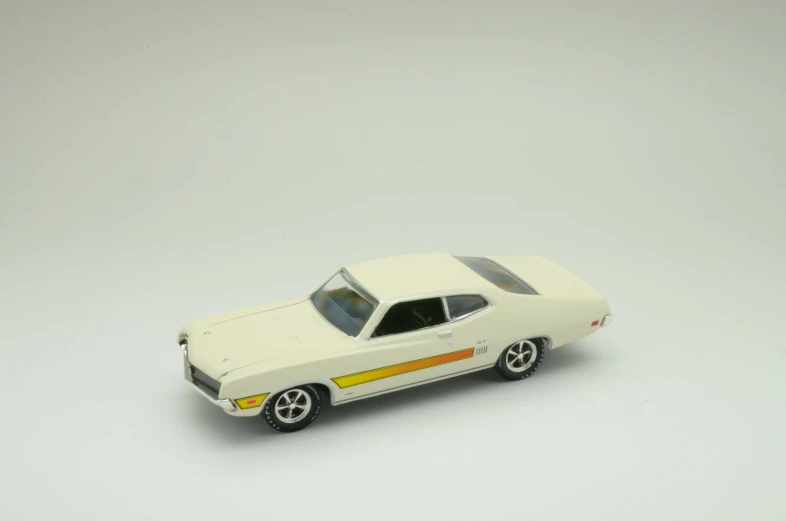 a white toy car with yellow stripes parked on a table